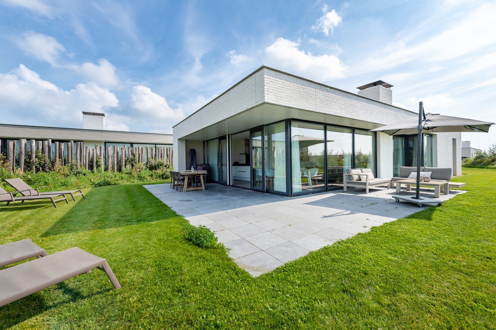 Terrasse mit Sonnenschirm im Ferienhaus Duinvallei 19 in Kamperland, ideal zum Entspannen