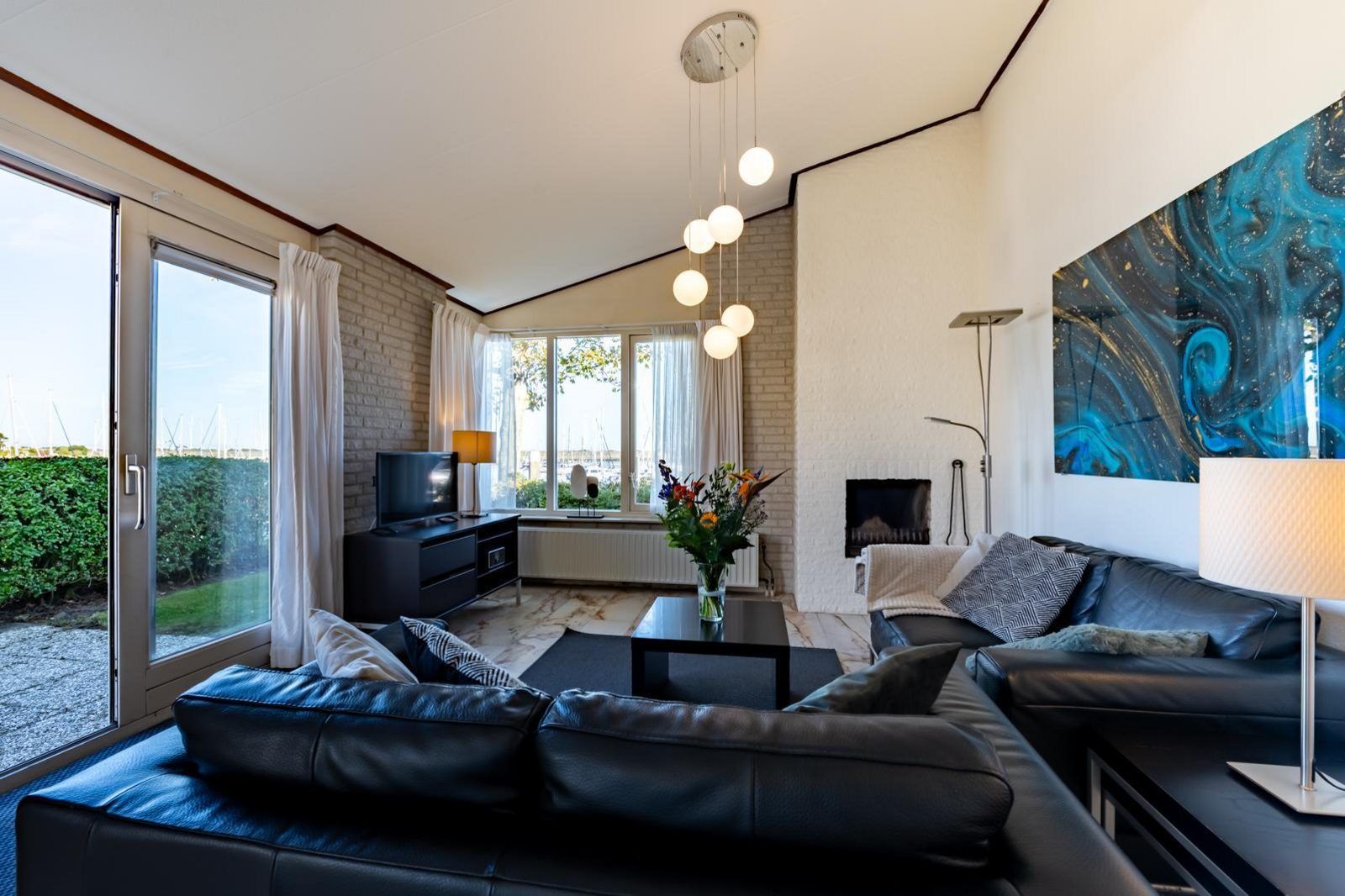 Lichte woonkamer met uitzicht op de tuin bij Sophiaboulevard 15, Roompot Beach Resort in Kamperland, Noord-Beveland.