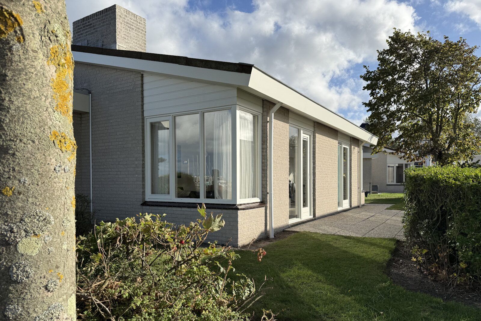 Buitenkant van vakantiehuis Sophiaboulevard 15, Roompot Beach Resort in Kamperland, Zeeland. Omgeven door groen.