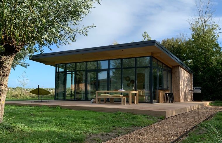 Modernes Ferienhaus in Kamperland mit Glasfassade und Holzterrasse, gelegen in Noord-Beveland, Zeeland.