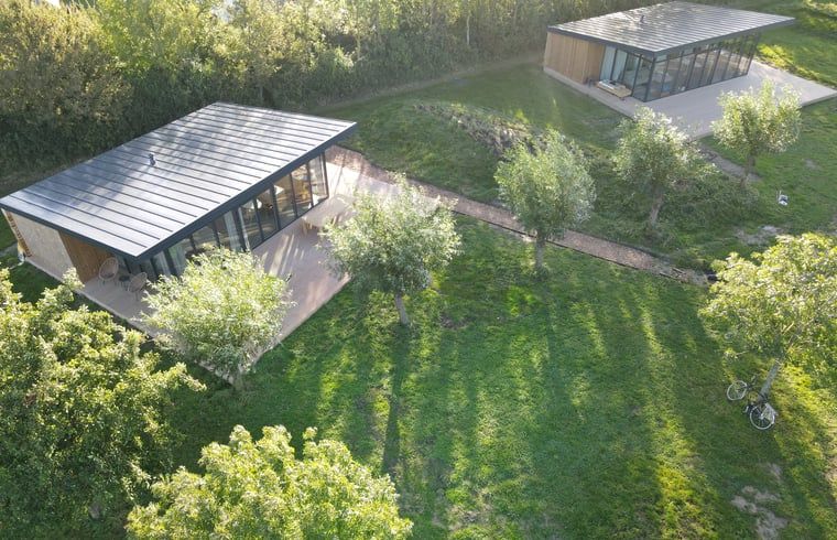 Luftaufnahme des Ferienhauses in Kamperland, umgeben von gruener Landschaft in Nord-Beveland, Zeeland.