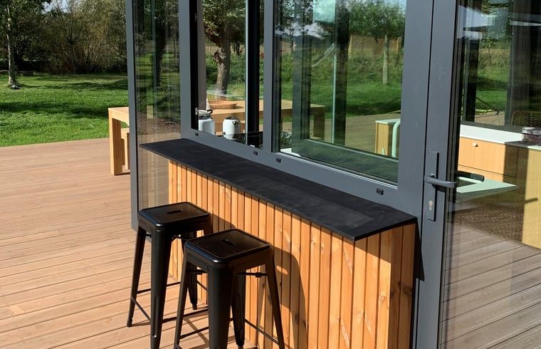 Aussenterrasse des Ferienhauses Kamperland mit moderner Bar und Sitzgelegenheiten, gelegen in Noord-Beveland, Zeeland.