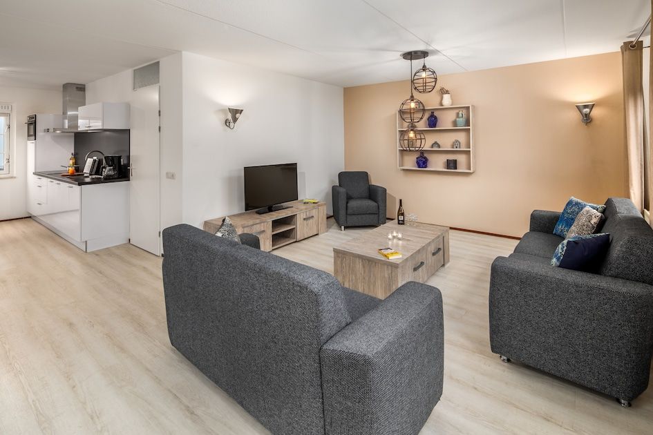 Stilvolles Wohnzimmer der Villa R6C, einem Ferienhaus in Kamperland, Noord-Beveland, Zeeland mit moderner Einrichtung und bequemer Sitzecke.