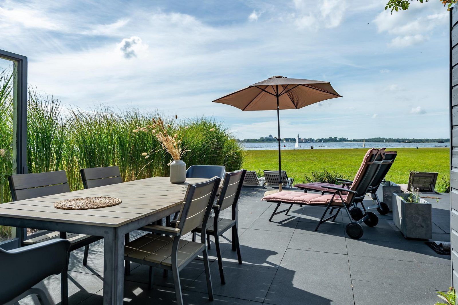 Geniet van het terras van VZ2312 Vakantiehuis in Kamperland met uitzicht op het meer in Noord-Beveland, Zeeland.