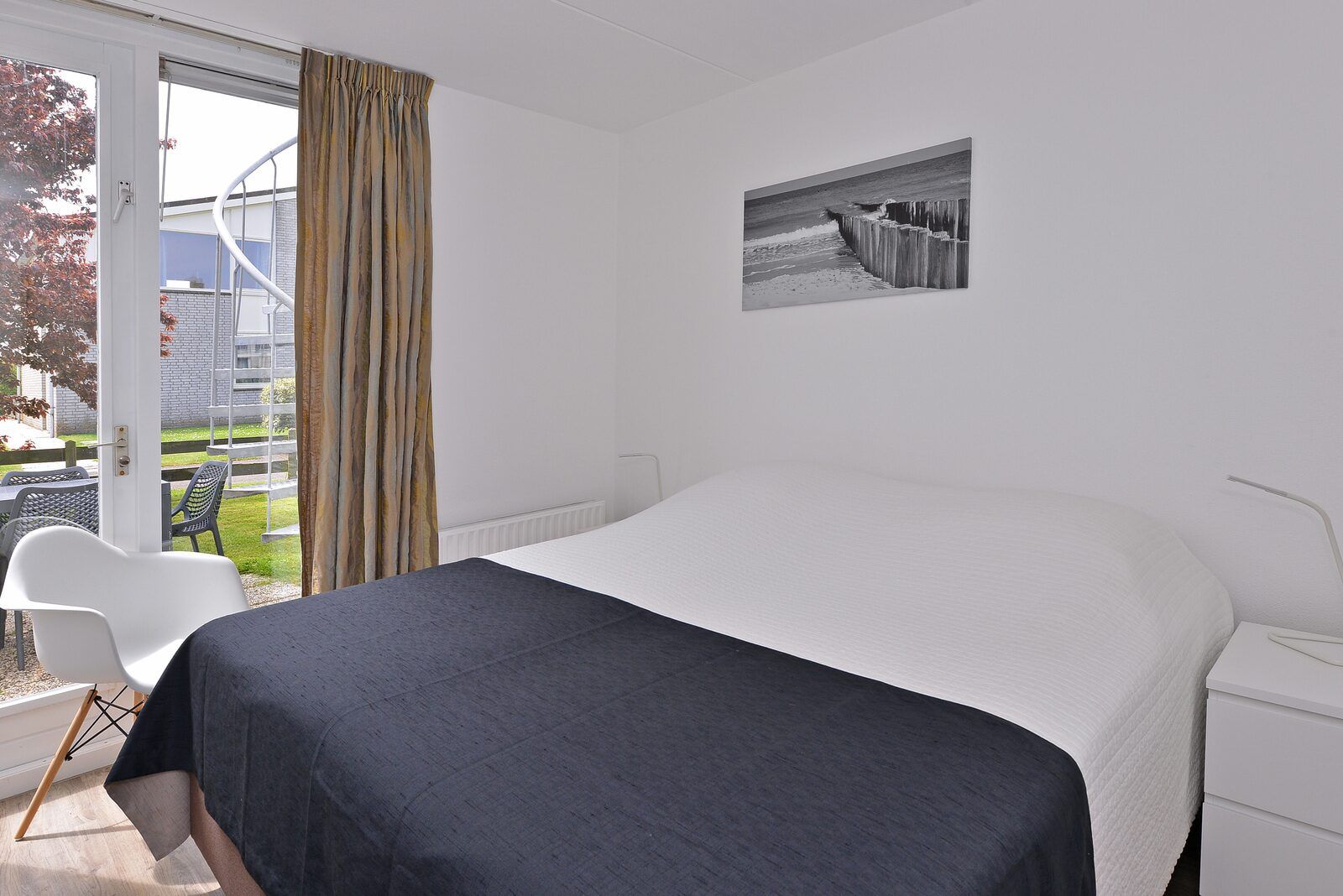 Slaapkamer met uitzicht op tuin in Ostrea 106, Roompot Beach Resort, Kamperland in Noord-Beveland, Zeeland.