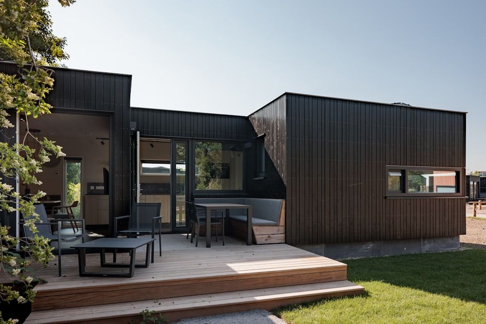Veranda van Lodge 4 in Kamperland, een modern vakantiehuis op Noord-Beveland, Zeeland, met uitzicht op de groene omgeving.