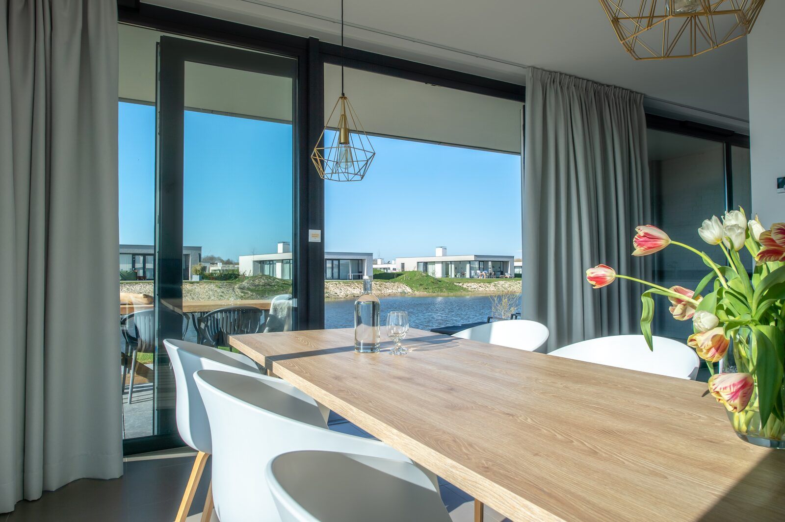 Eetkamer in Waterlijn 03 | De Groote Duynen, vakantiehuis in Kamperland, Noord-Beveland, met uitzicht op het meer.