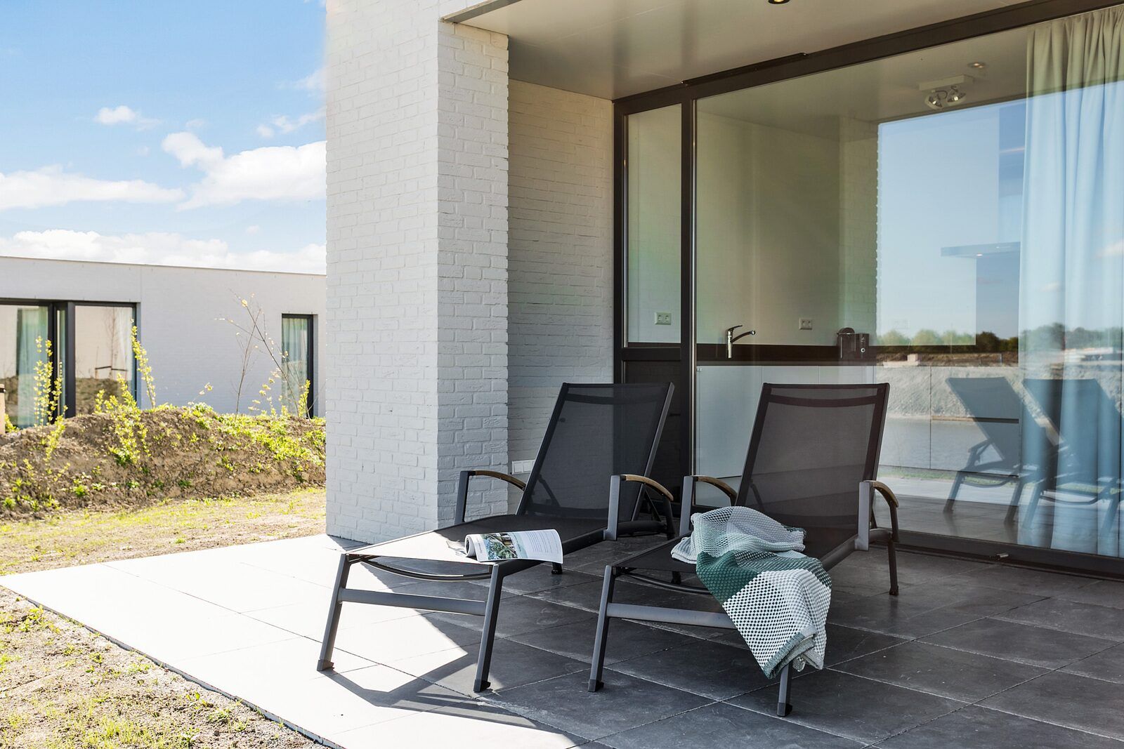 Terras met ligstoelen in Waterlijn 03 | De Groote Duynen, vakantiehuis in Kamperland, Noord-Beveland, Zeeland.
