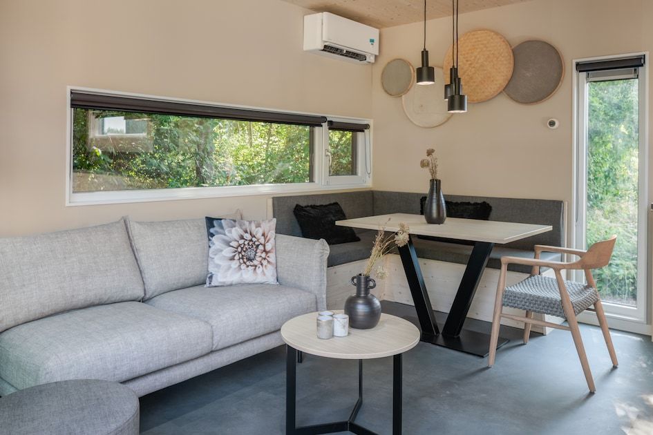 Gezellige binnenruimte van Lodge 4 in Kamperland, Noord-Beveland, met een moderne zithoek en uitzicht op de natuur van Zeeland.