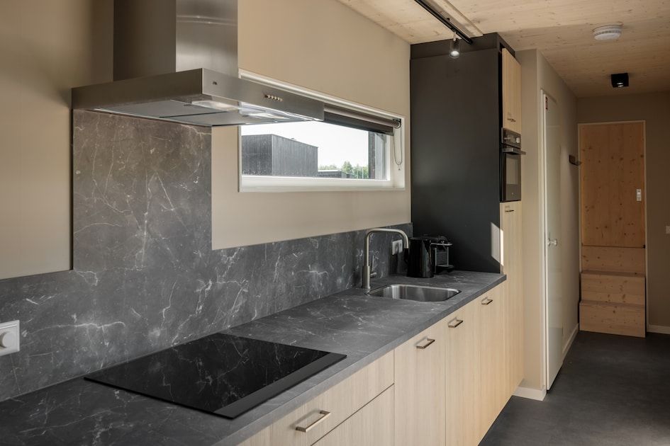 Moderne keuken in Lodge 4, een vakantiehuis in Kamperland, Noord-Beveland, Zeeland, met strakke inrichting en uitzicht op de omgeving.