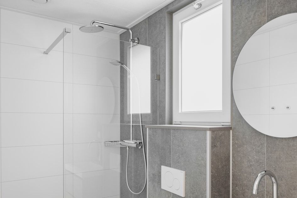 Moderne badkamer in Lodge 4, een glamping lodge in Kamperland, Noord-Beveland, Zeeland, met luxe regendouche en elegant design.