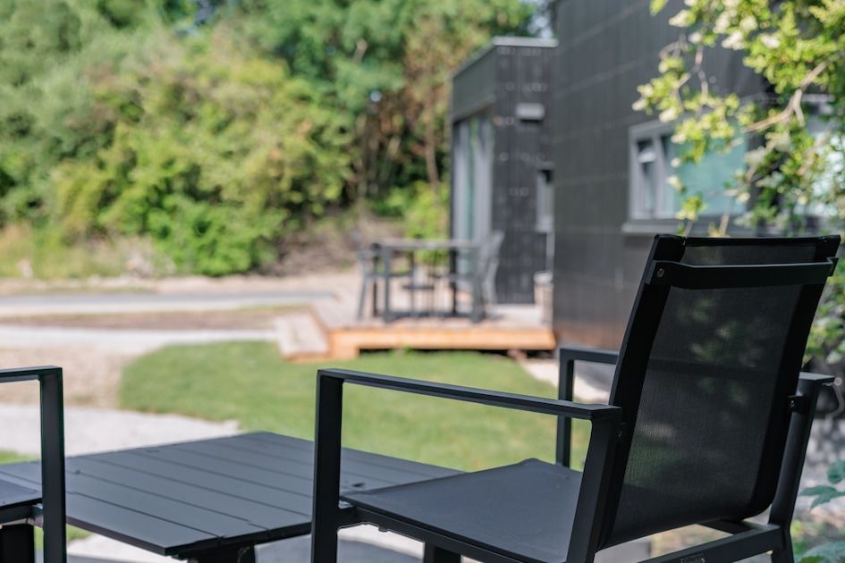 Geniet van het terras bij Lodge 4, een glamping lodge in Kamperland, Noord-Beveland, met uitzicht op de groene omgeving van Zeeland.