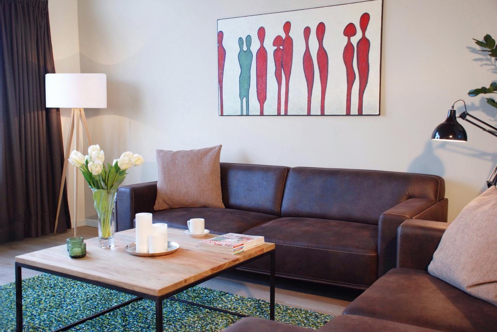 Gemuetliches Wohnzimmer des Ferienhauses VZ1178 in Kamperland, mit bequemem Sofa und Kunst an der Wand.