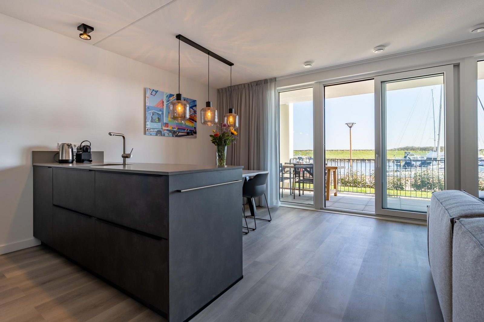 Open keuken en eetruimte in Harbour Loft 1E, Noord-Beveland, met uitzicht op het terras.
