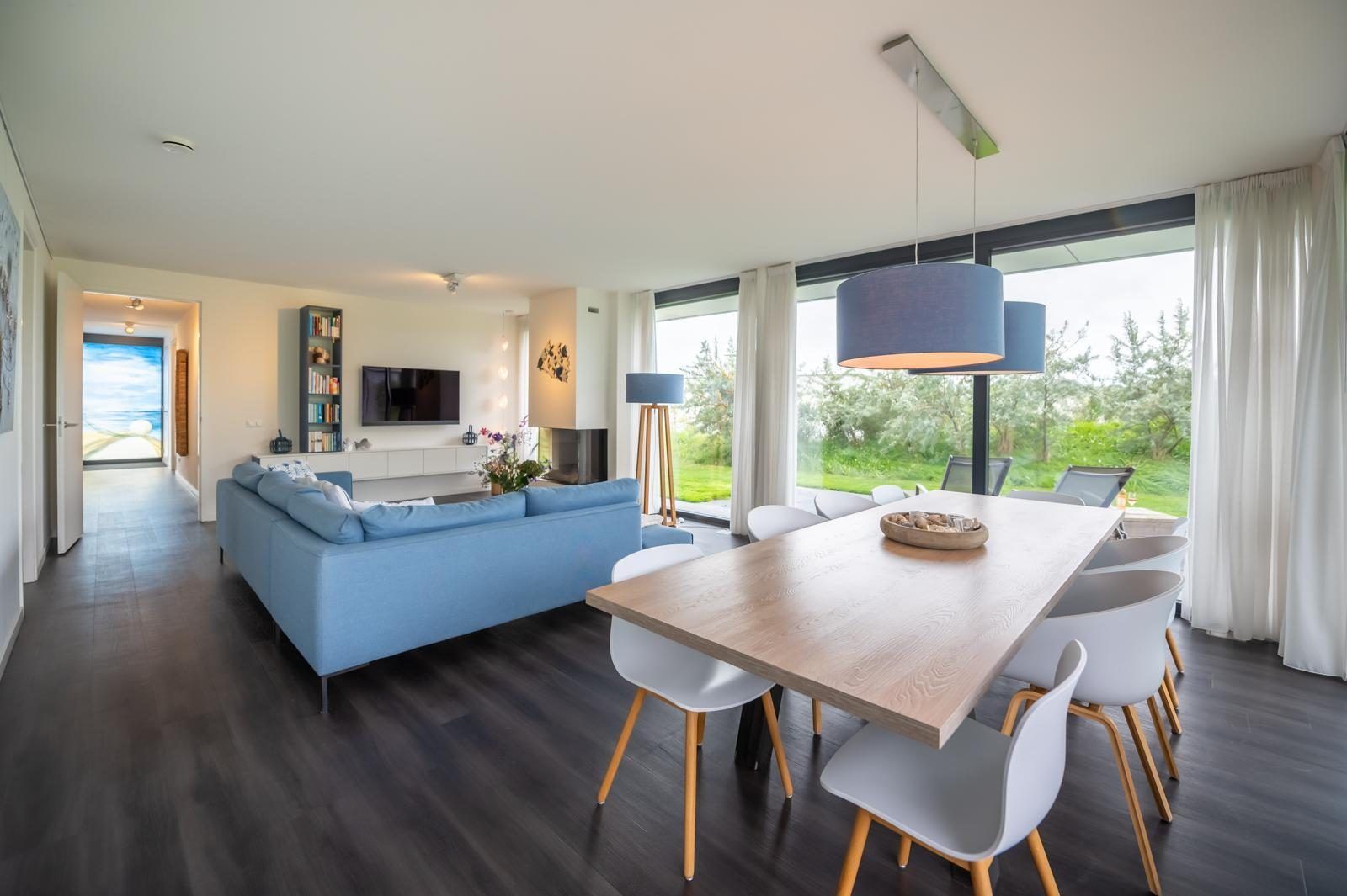 Esszimmer in Duinvallei 09, Ferienhaus in Kamperland, Zeeland, mit grossem Tisch und Blick auf die gruene Umgebung.