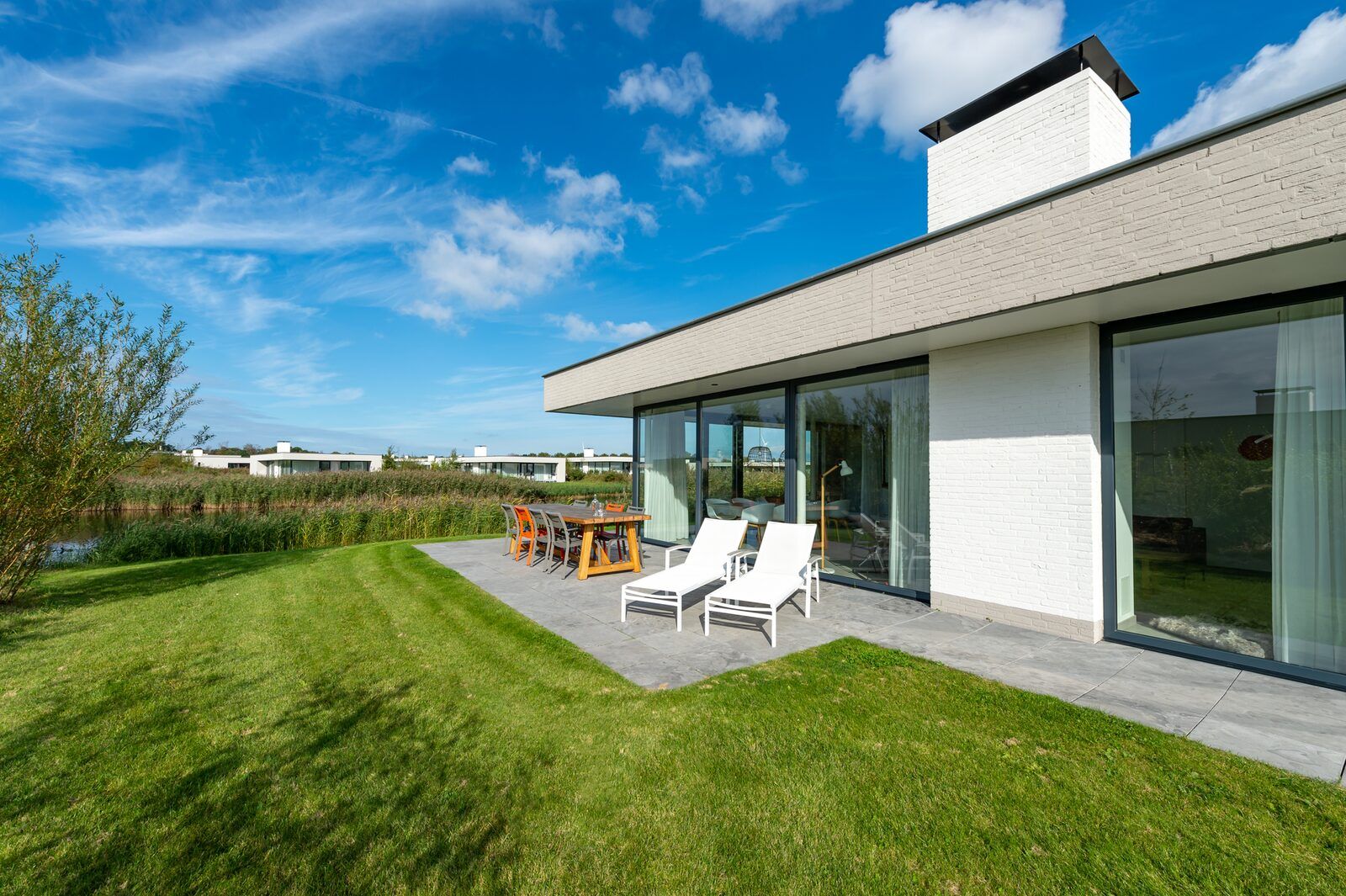 Sunny terrace with deck chairs at Waterline 09, vacation home in Kamperland, Zeeland.