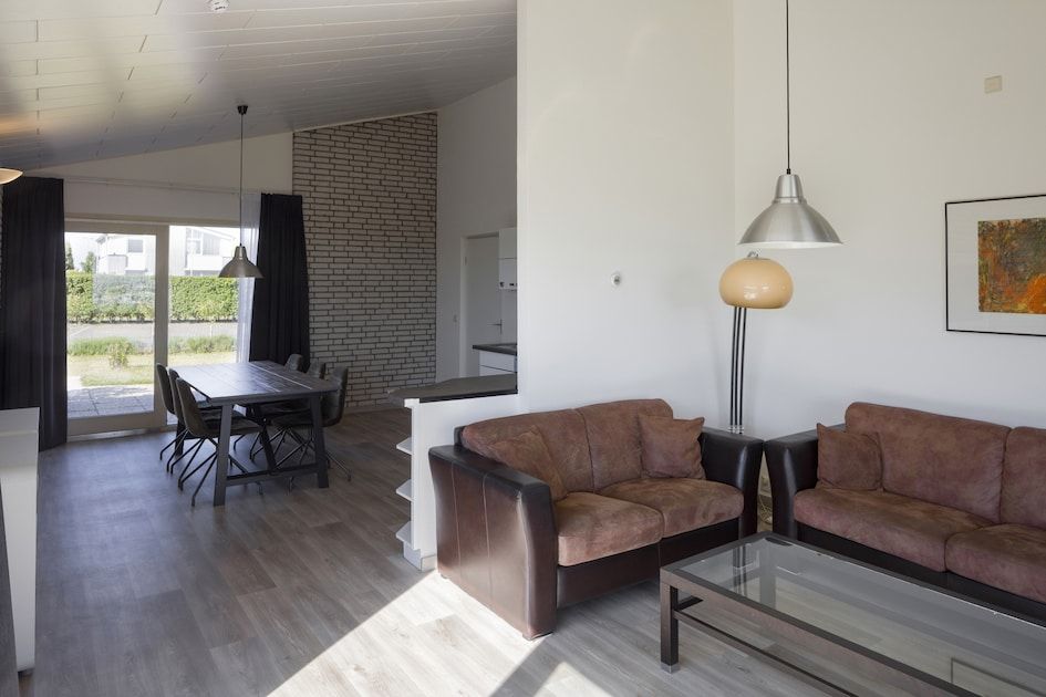 Stilvolles Wohnzimmer des BA-Bungalows in Kamperland, Noord-Beveland, mit bequemer Sitzecke und Gartenblick.