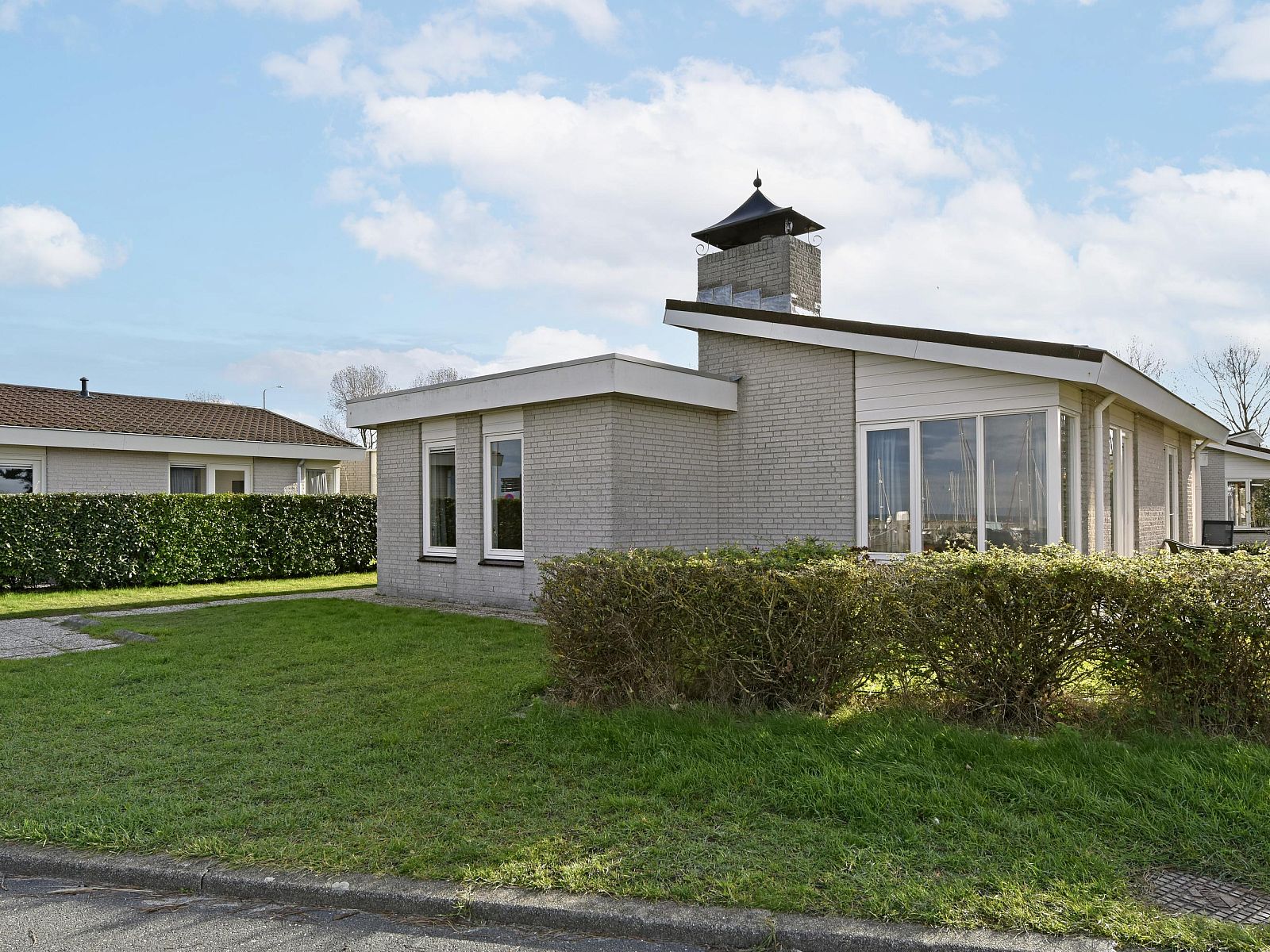 Freistehendes Haus in Kamperland, ein Ferienhaus in Nord-Beveland, Zeeland, mit moderner Architektur und einem grnen Garten.