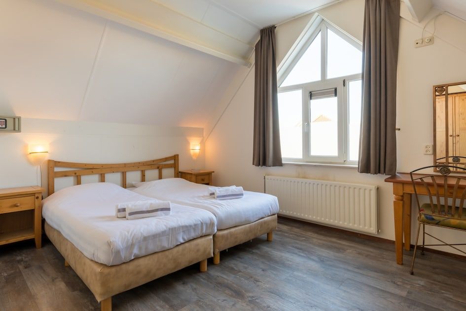 Moderne badkamer in Villa 5B, een vakantiehuis in Kamperland, Noord-Beveland, met ligbad en strak design voor ultiem comfort.