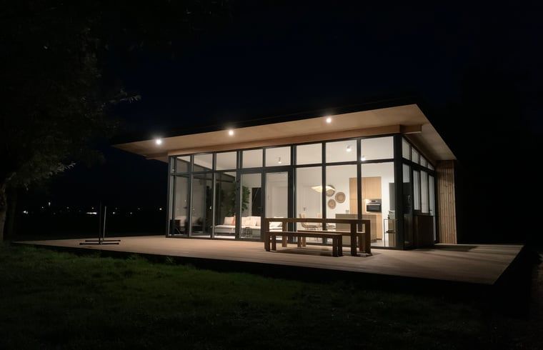 Vacation home in Kamperland lit in the evening, offers a warm atmosphere in North Beveland, Zeeland.
