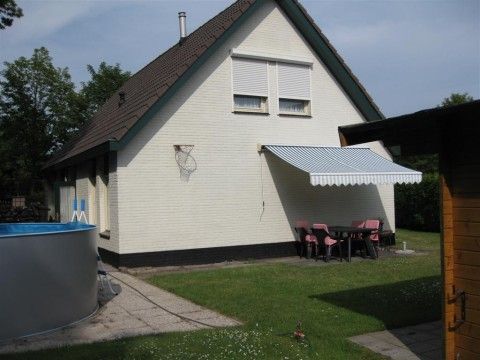 Backyard of vacation home Mi Casa in Burgh-Haamstede with terrace and swimming pool, perfect for summer days.