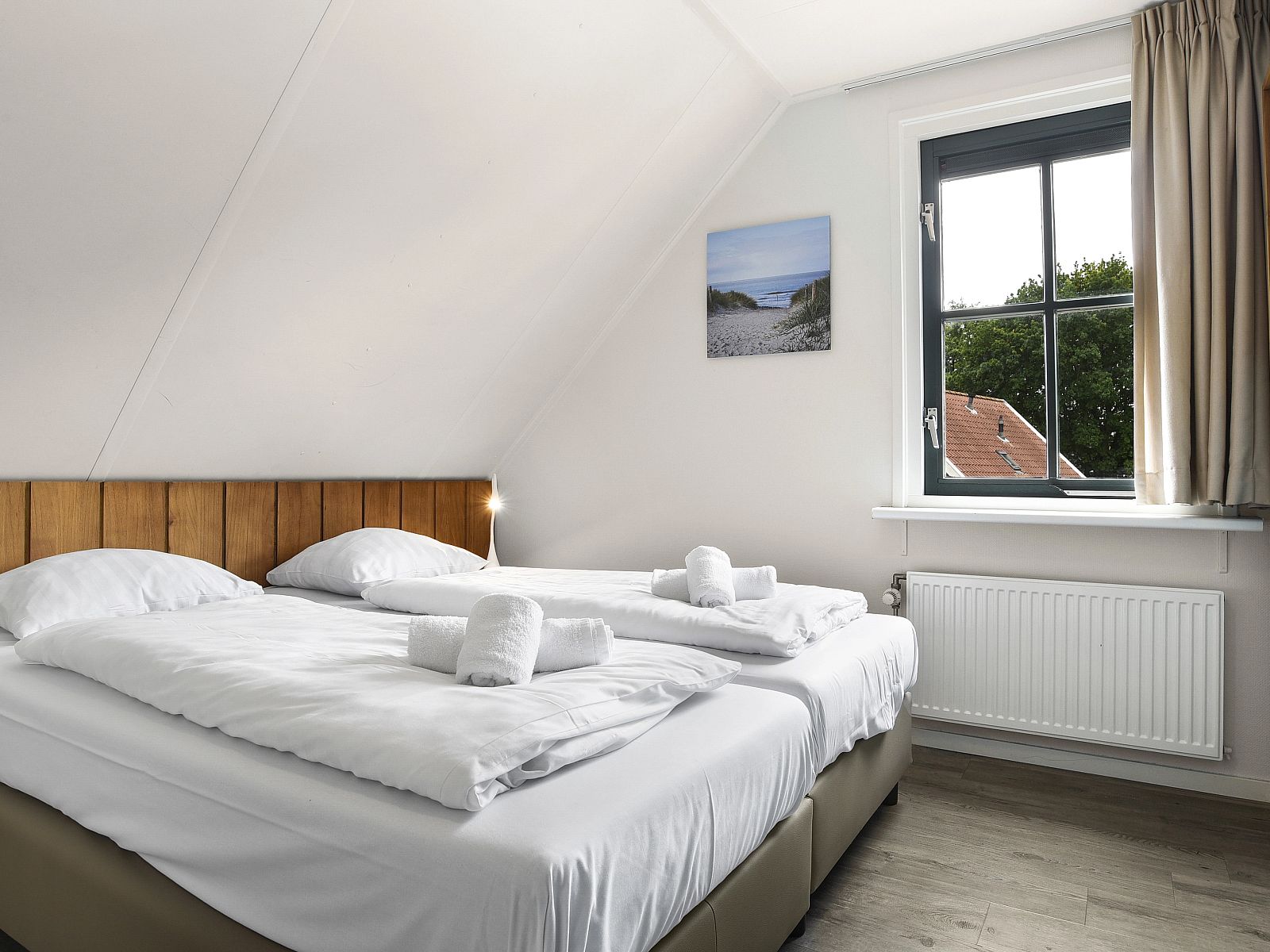 Aussenterrasse mit Sonnenschirm im Duinpark 't Hof van Haamstede 8-Personen-Bungalow 8CE, ideal fuer sonnige Tage.