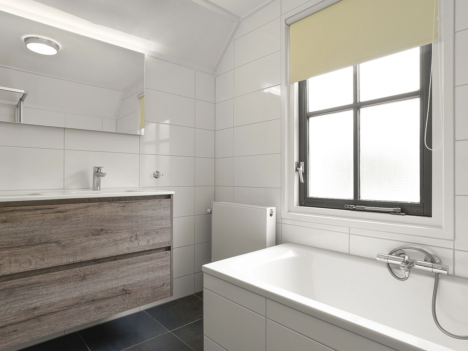 Schlafzimmer im Duinpark 't Hof van Haamstede 8-Bett-Bungalow 8CE, mit Holzakzenten und Leselampe.