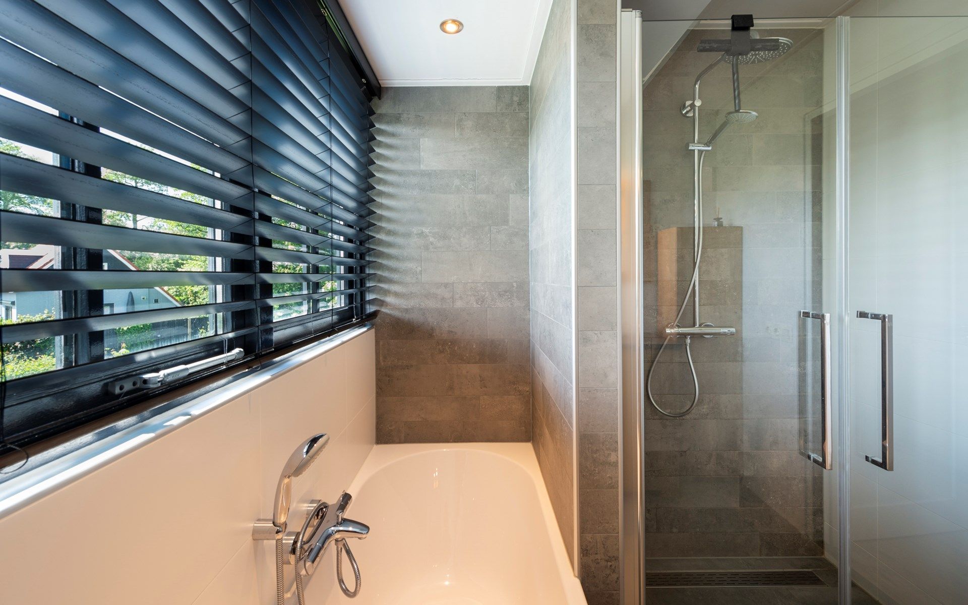 Luxe badkamer met bad en douche in Vakantievilla Paardenbos 5 in Burgh-Haamstede, een comfortabele vakantiewoning in Zeeland.