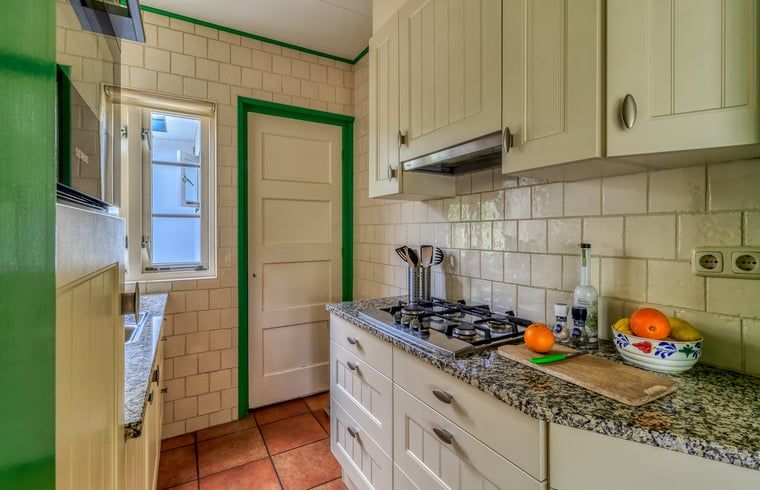 Kompakte Kueche im Ferienhaus in Burgh-Haamstede, ausgestattet mit modernen Geraeten in Zeeland.