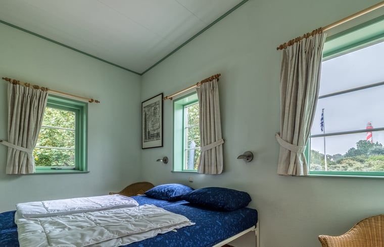 Zweites Schlafzimmer im Ferienhaus in Burgh-Haamstede mit Blick auf den Garten in Schouwen-Duiveland.