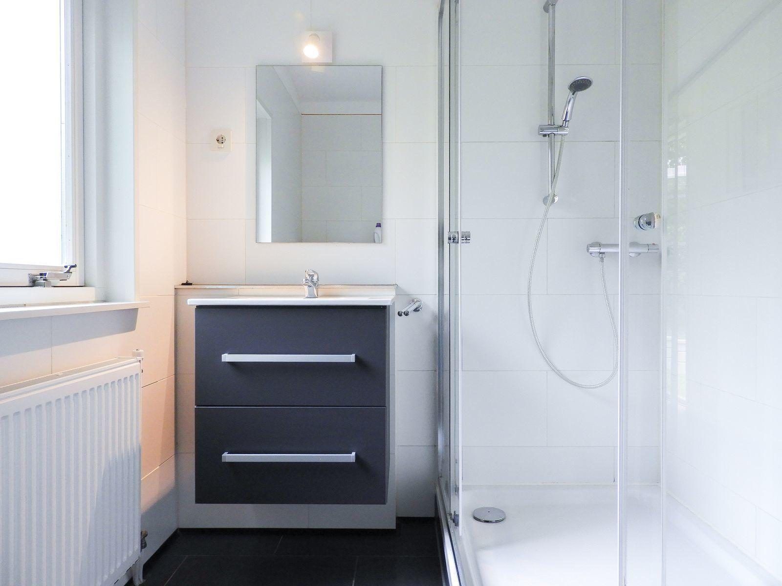 Badkamer met douchegordijn in VZ345 Vakantiehuis Burgh-Haamstede, Zeeland.