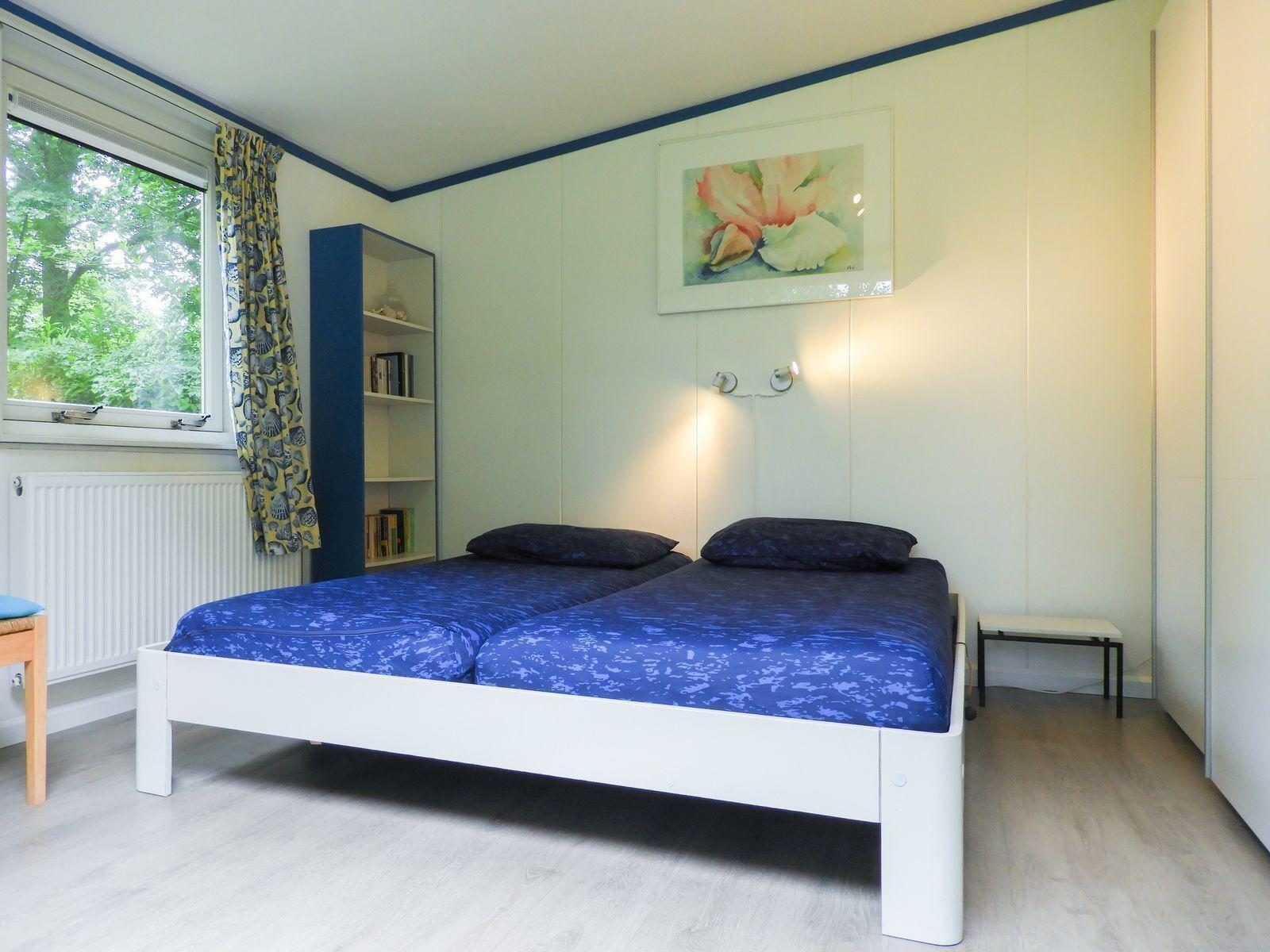 Slaapkamer met openslaande deuren naar terras in VZ345 Vakantiehuis Burgh-Haamstede.