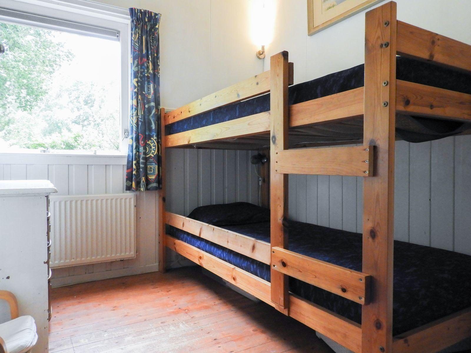 Kast en stoel in slaapkamer van VZ345 Vakantiehuis Burgh-Haamstede, Zeeland.