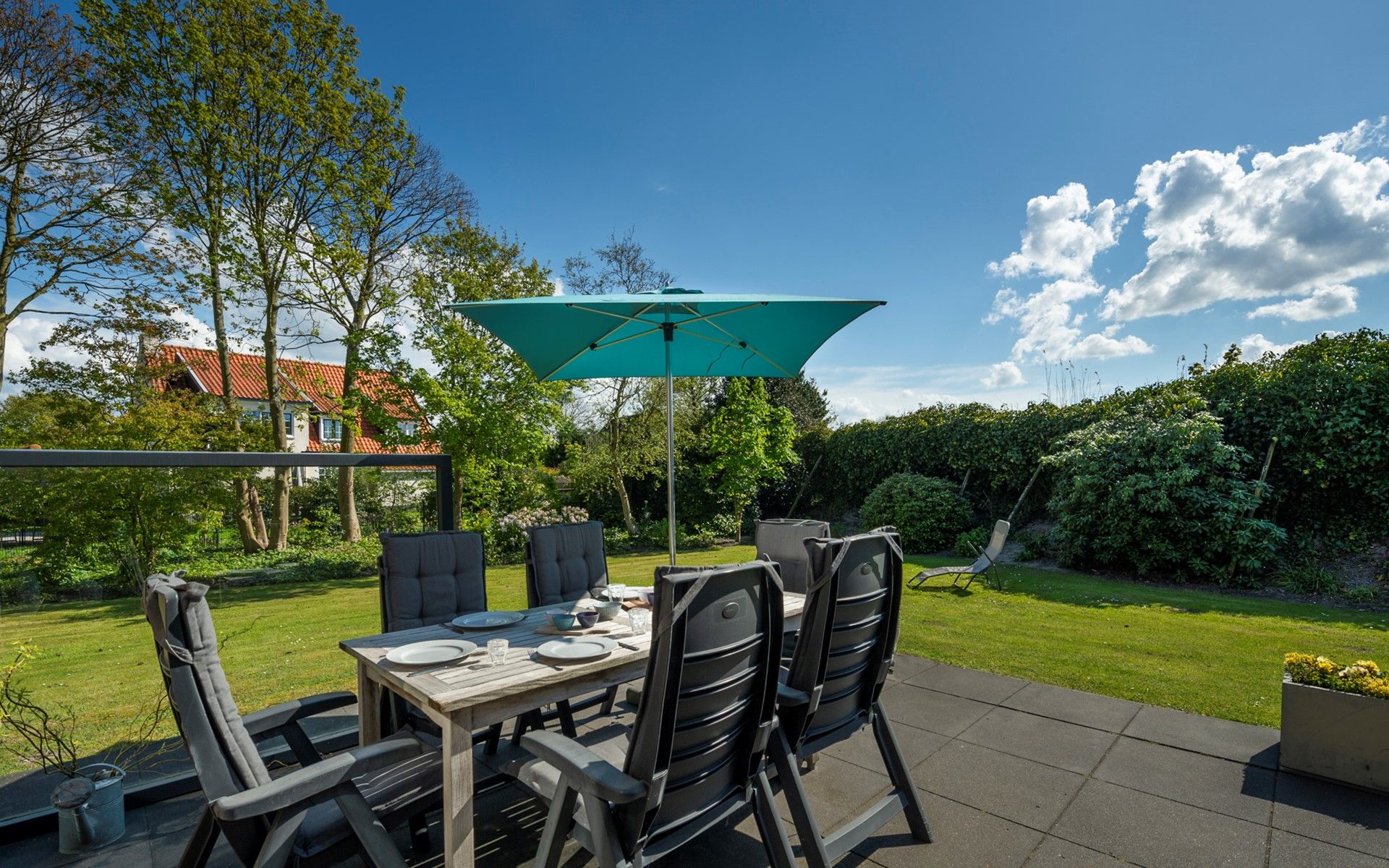 Terrace of Holiday home Schouwse Duin 35 in Burgh-Haamstede with garden table and parasol for summer days in Zeeland.