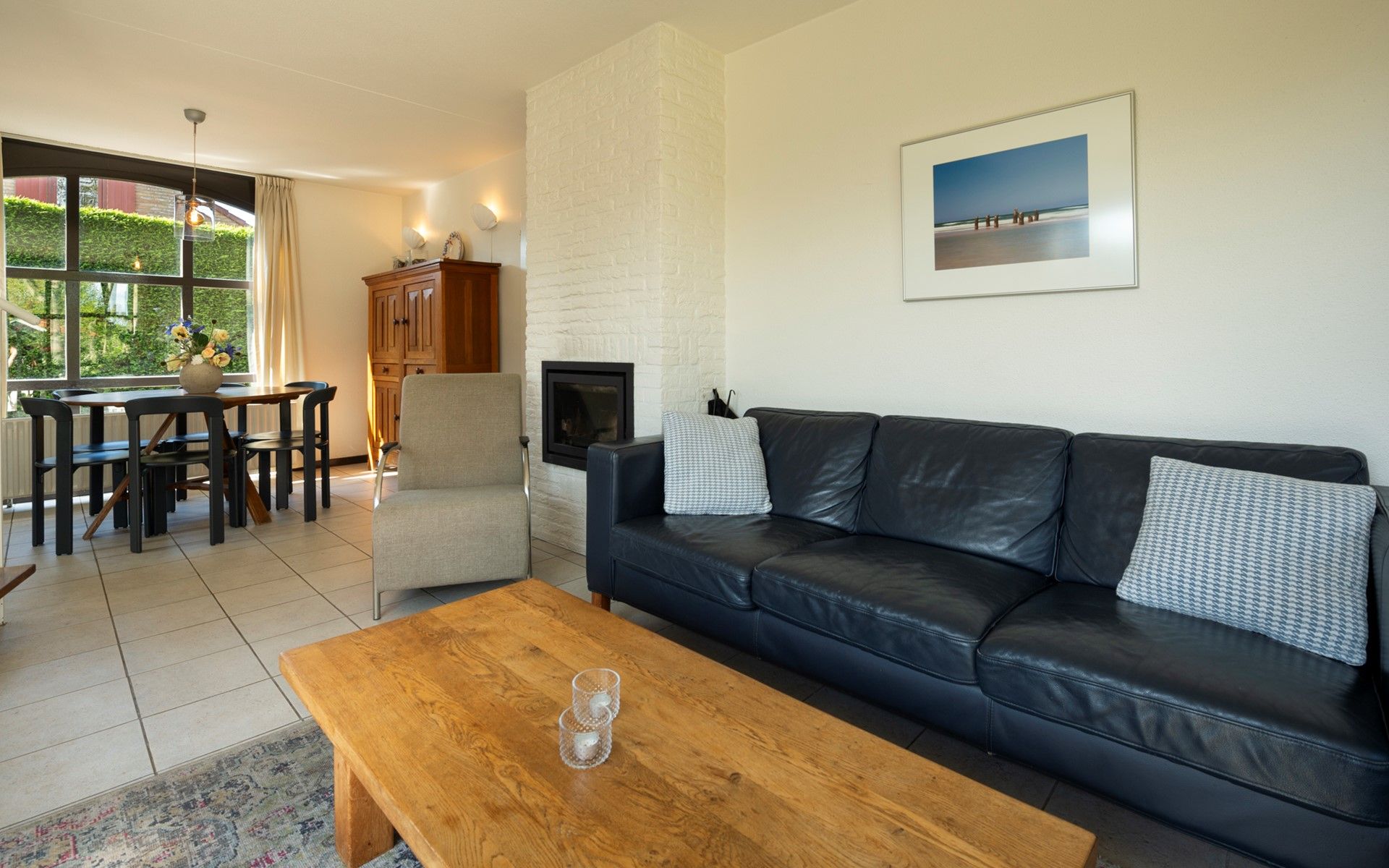 Dining room in Vakantiewoning Schouwse Duin 35, Burgh-Haamstede, with wooden table and garden view in Zeeland.