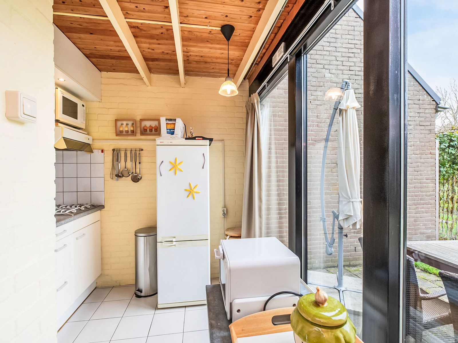 Keuken met uitzicht op het terras in Vakantiehuis Buitenplaats Schouwen nr 86, Zeeland.