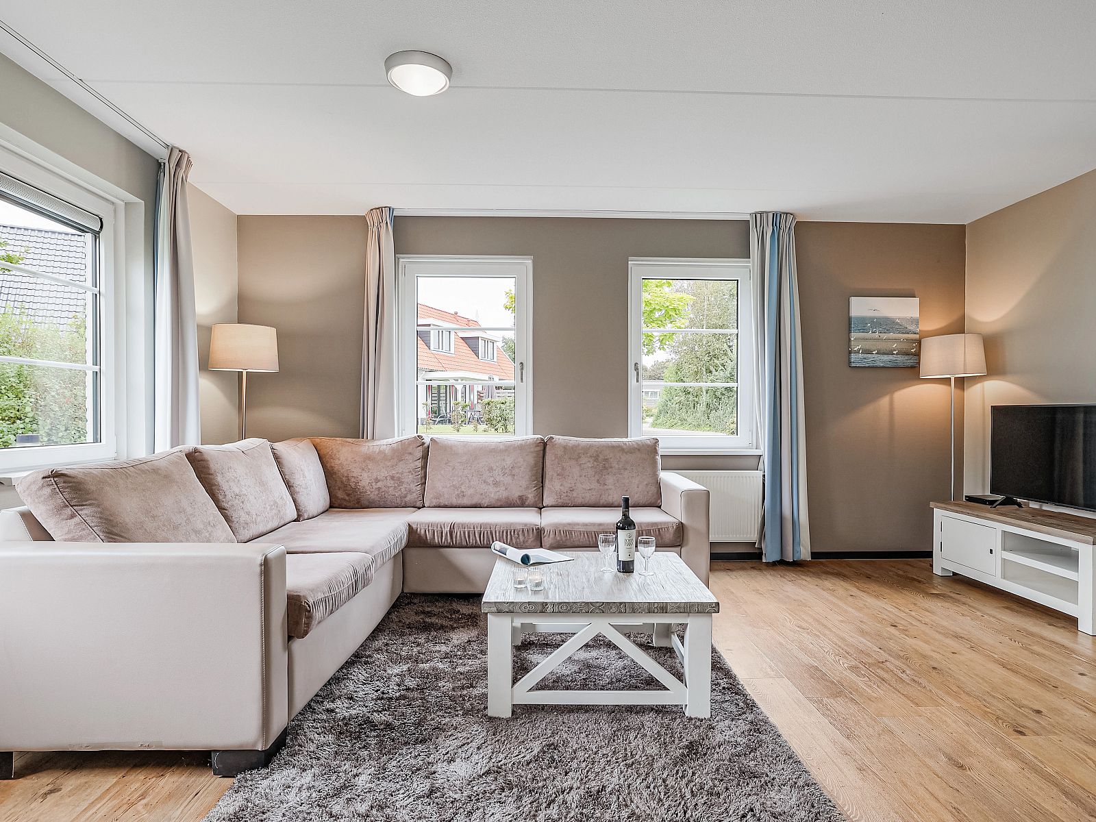 Ueberdachter Esstisch im Resort Haamstede 6-Bett-Bungalow 6D, Burgh-Haamstede, mit Geschirr und Weinglas.