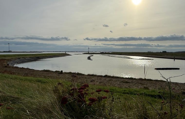 Sonniger Aussenbereich mit bunten Sitzgelegenheiten im Huisje in Bruinisse, Schouwen-Duiveland.