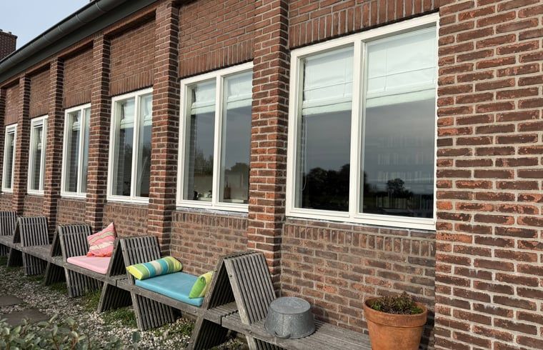 Gemuetlicher Innenraum mit Esstisch und Buecherregalen im Cottage in Bruinisse, Zeeland.