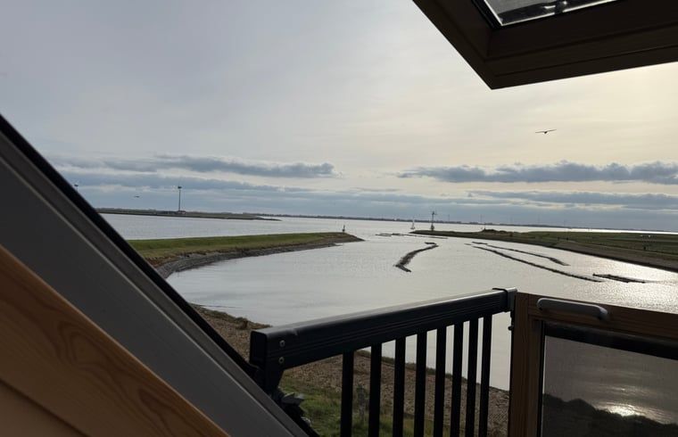 Esszimmer mit Holztisch und bunten Stuehlen in Cottage in Bruinisse, Schouwen-Duiveland.