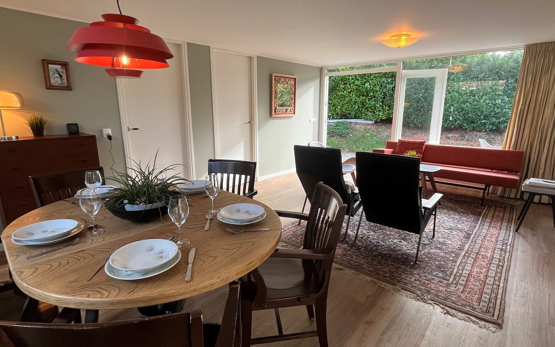 Gezellige binnenruimte van Vakantiewoning Het Ongerepte 21 'Kaatje Mossel' in Renesse, Zeeland, met eetgedeelte en uitzicht op de tuin.