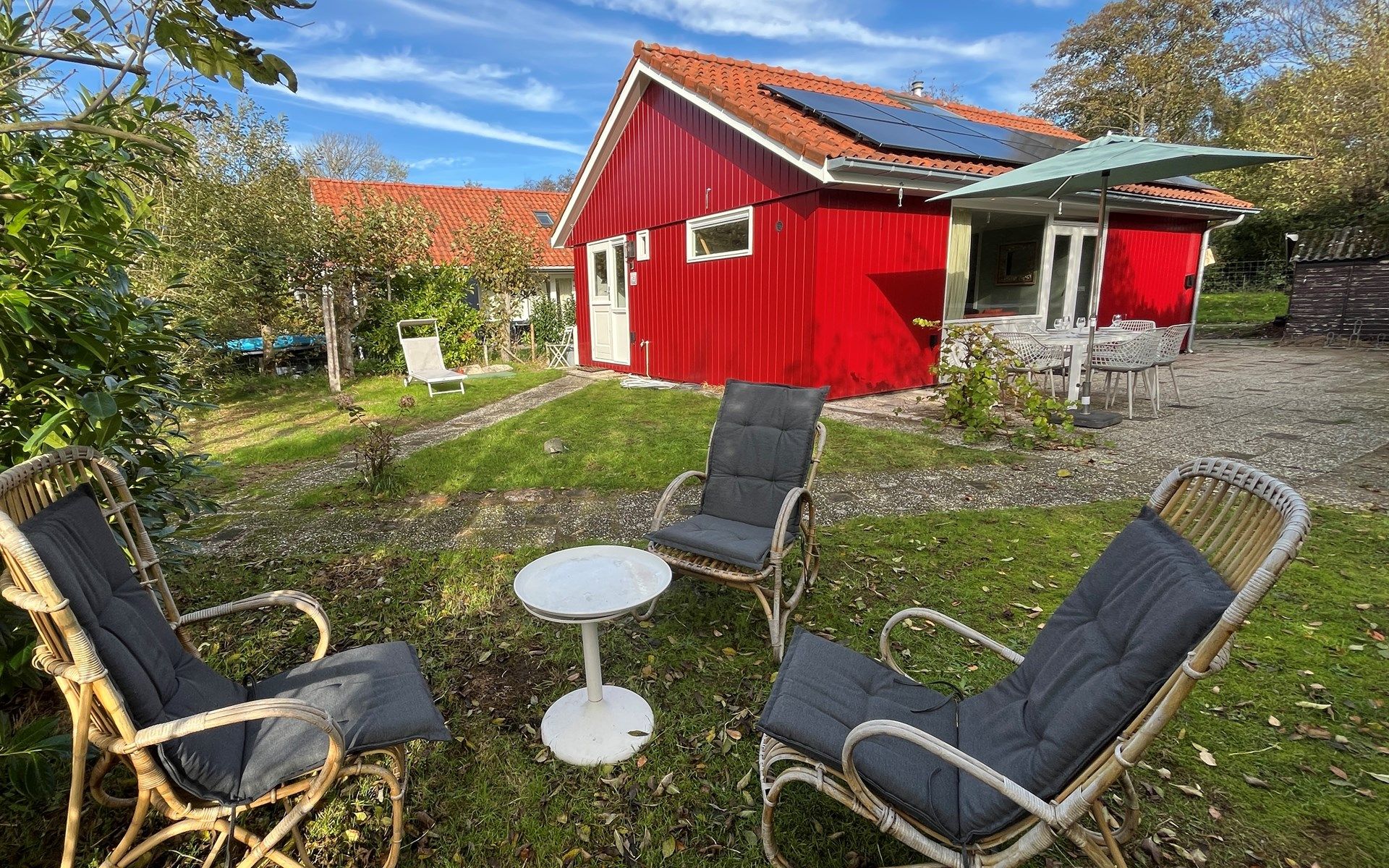 Vakantiewoning Het Ongerepte 21 'Kaatje Mossel' in Renesse, Zeeland, met zonnig terras en groene tuin voor een ontspannen verblijf.