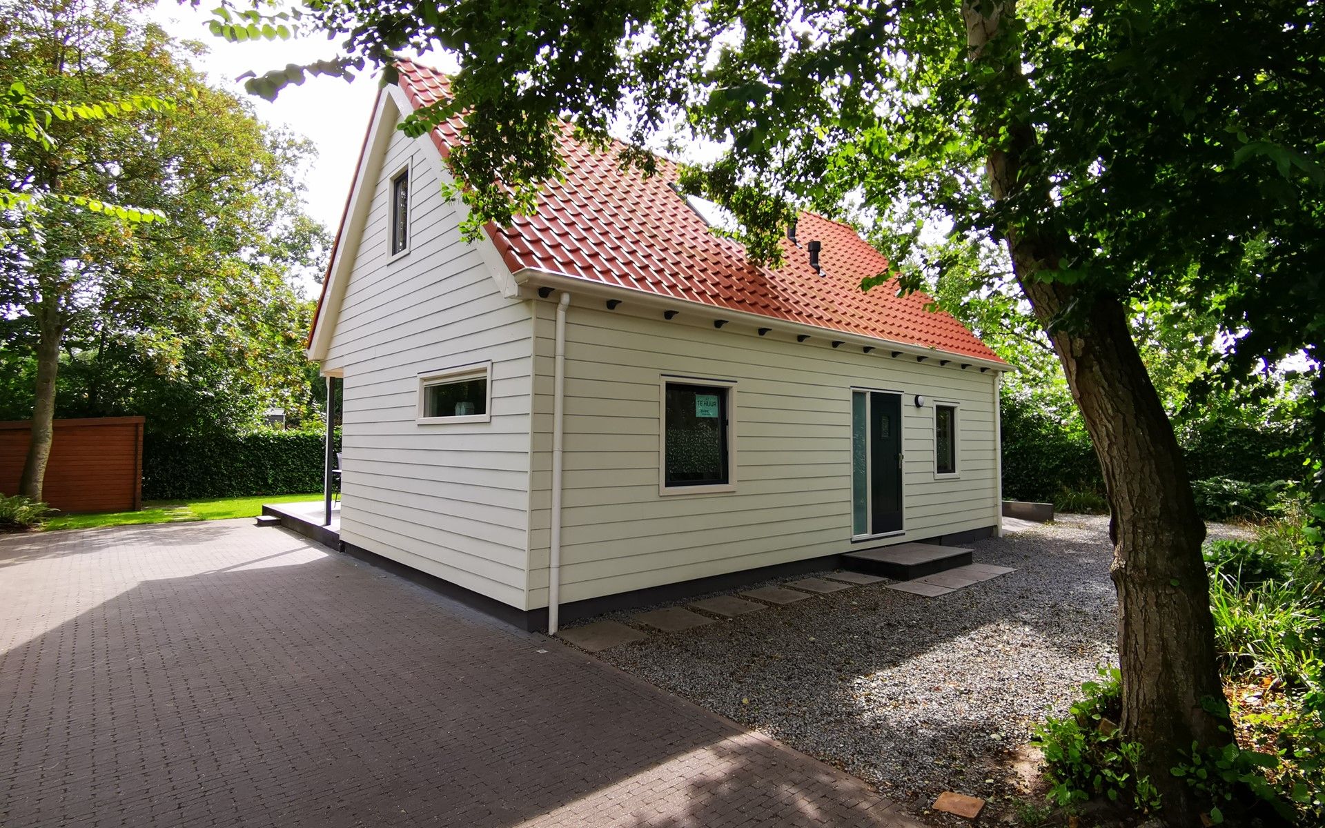 Seitenansicht des Ferienhauses Duinweg 12 in Renesse, umgeben von Natur in Zeeland.