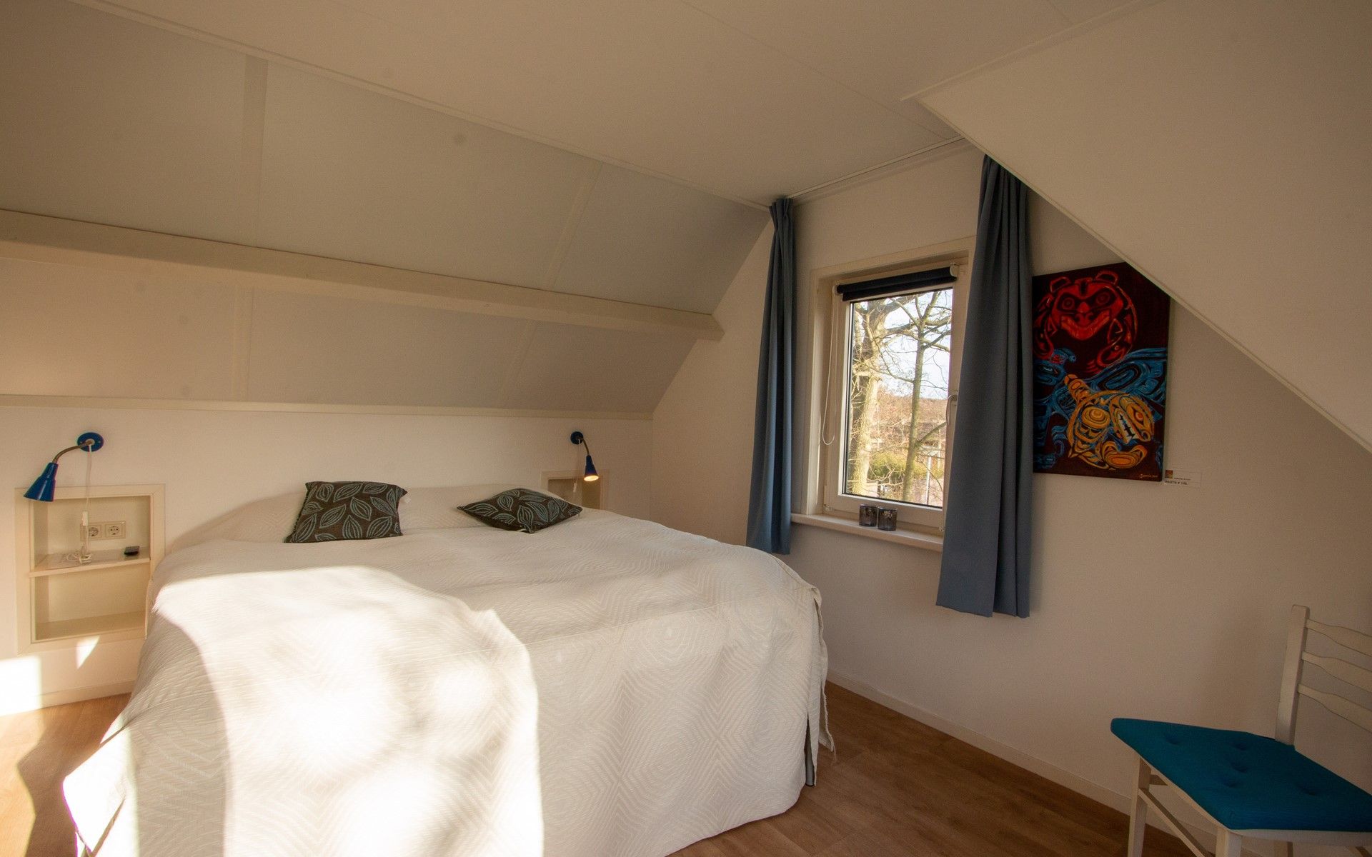 Schlafzimmer mit Kunst und natuerlichem Licht im Ferienhaus Duinweg 12 in Renesse, Zeeland.