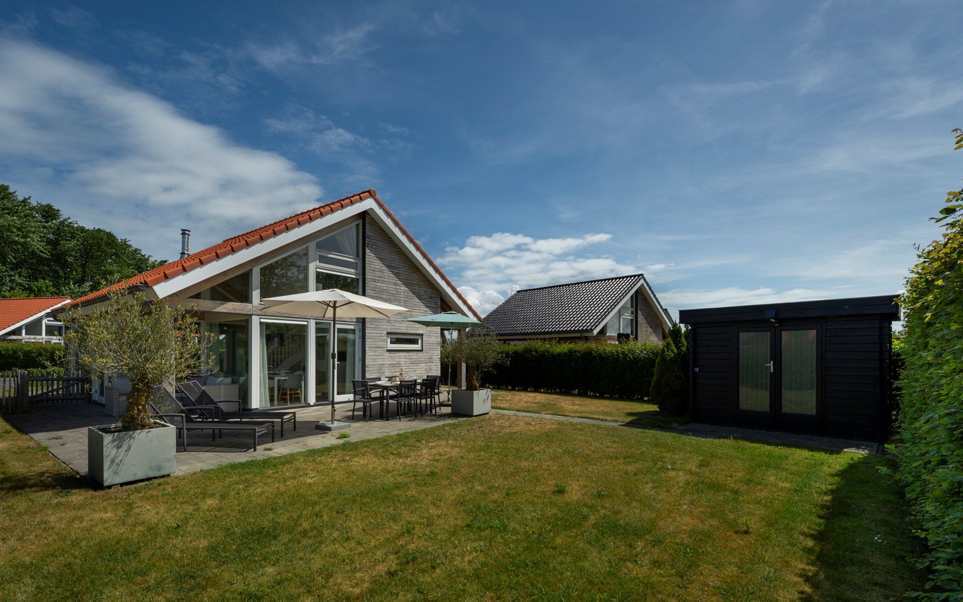 Terrasse des Ferienhauses Zonnedorp 8, De Zeehond in Renesse, Zeeland mit bequemen Liegestuehlen.