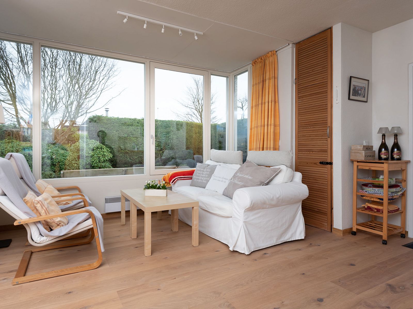 Bright living room in Holiday Home Horizon by the Sea, Renesse, with comfortable seating and views of the garden.