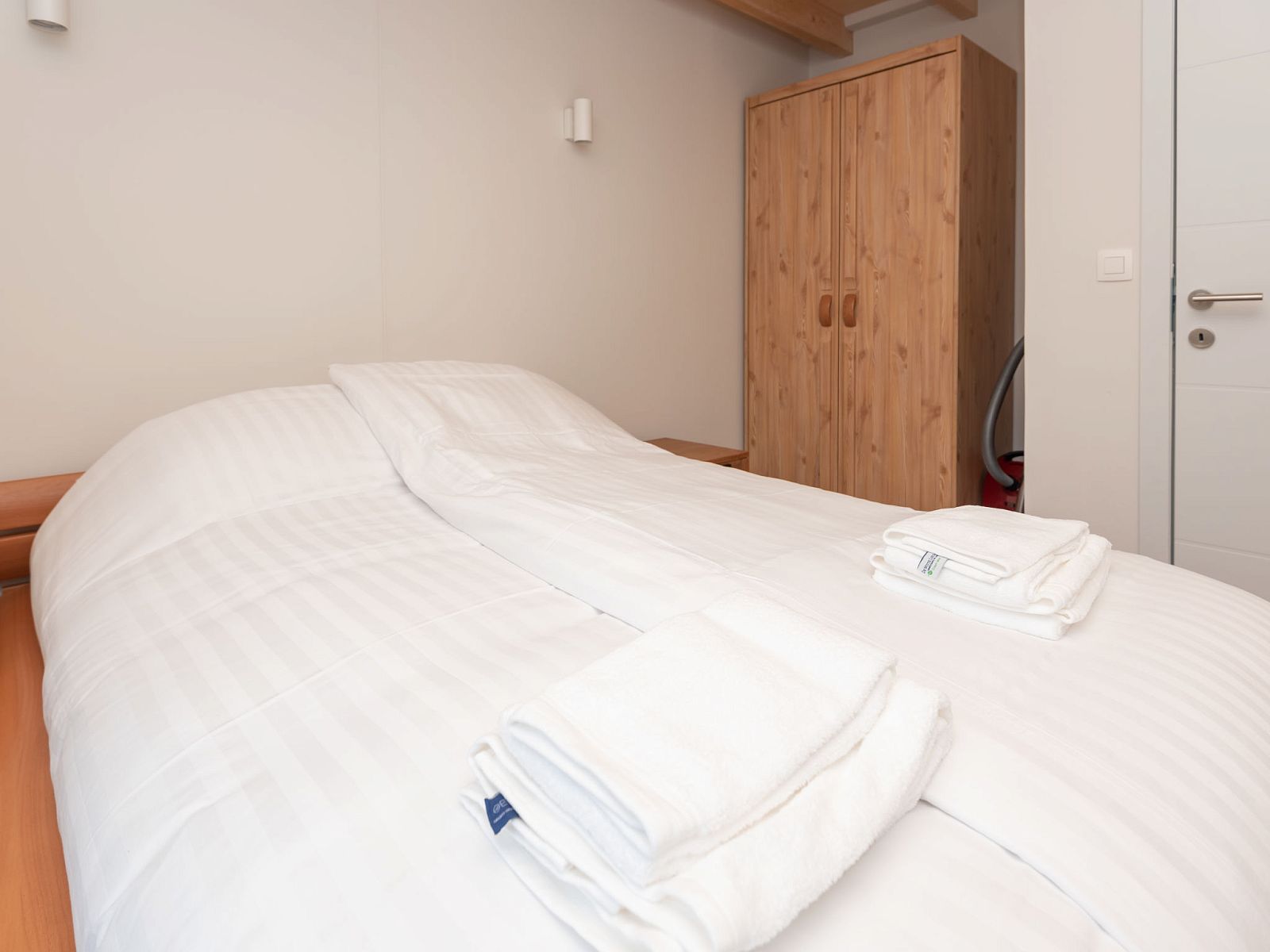 Bedroom with wooden closet in Holiday Home Horizon by the Sea, Renesse, offers plenty of storage space.