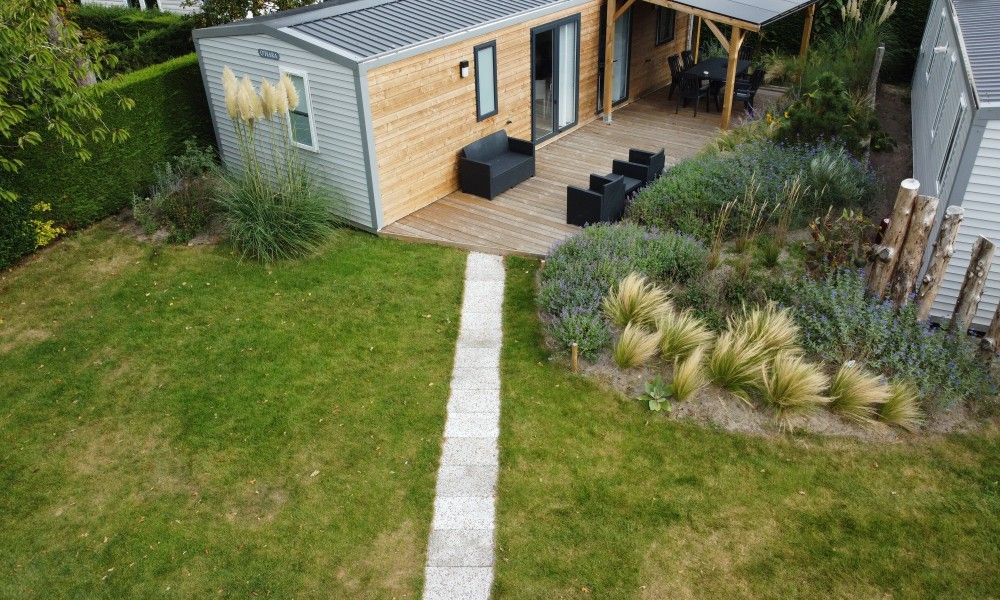 Verseputshofje chalet in Renesse, Schouwen-Duiveland, Zeeland met een uitnodigende veranda en weelderige tuinomgeving.