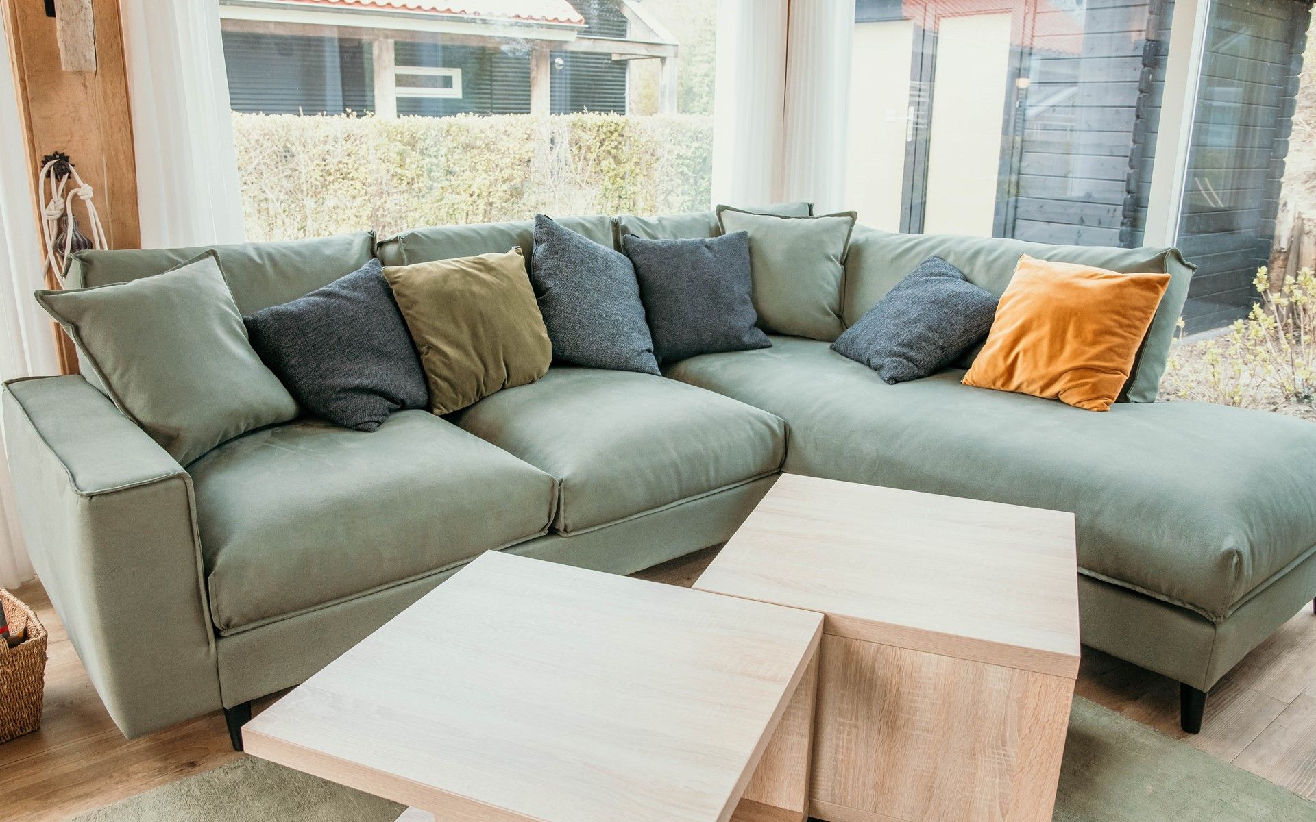 Cozy sitting area in vacation home Zonnedorp 14 Mon Repos in Renesse with green sofa and cushions