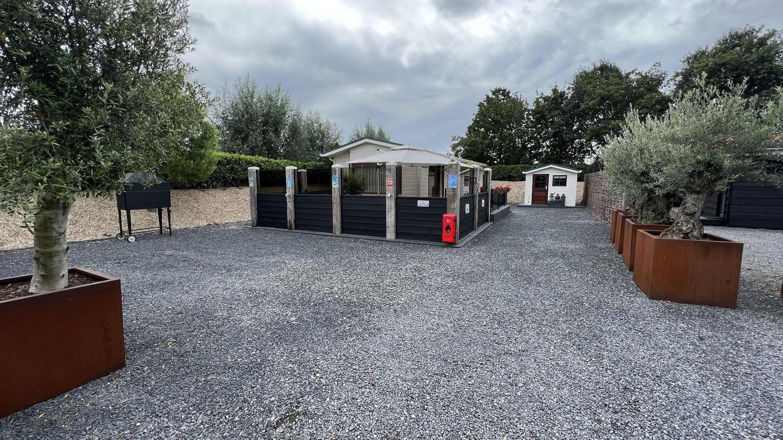 Ruime buitenruimte bij VZ2321 Vakantiechalet in Renesse, omgeven door groen in Zeeland.